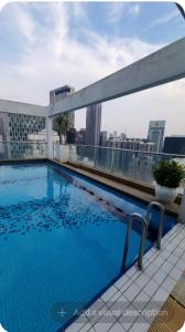 a swimming pool on the roof of a building at Klcc Cozy Unit in Kuala Lumpur