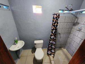 a bathroom with a toilet and a sink at Calala House in Balgue +41 photos