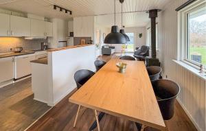 a kitchen and dining room with a wooden table and chairs at Cozy Home In Sydals With Sauna in Skovby