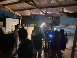 a group of people standing around a table in a room at Urban Jungle Hostel in San Miguel de Tucumán