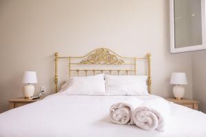 a bedroom with a white bed with two lamps at Casa Cáceres in Lima
