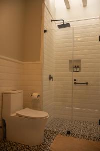 a bathroom with a toilet and a glass shower at Casa Cáceres in Lima