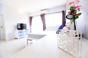 a living room with a couch and a table with flowers at Room 9 Residence in Pluak Daeng
