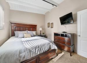 a bedroom with a bed and a flat screen tv at Contemporary Value 4 Bdr, with Rooftop Deck- 303 home in Newport Beach +23 photos
