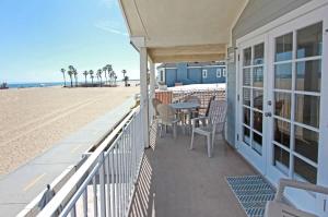 a balcony with a table and chairs on the beach at Ocean and Scenic Beach Views From Deck apts in Newport Beach