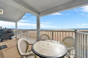 a balcony with a table and chairs on a beach at Ocean and Scenic Beach Views From Deck apts in Newport Beach