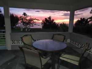 a table and chairs on a porch with a sunset at Sunset Haven in Wallhouse +7 photos