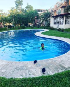 a man is swimming in a swimming pool at Casa Tortuga in Ixtapa