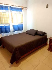 a bedroom with a large bed with a window at Casa Tortuga in Ixtapa