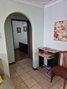 a living room with a table and a chair at Fully Airconditioned Geraldton Holiday Unit with free Streaming in Geraldton