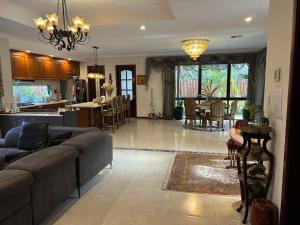 a living room and kitchen with a couch and a table at Midby's Elegant Guesthouse - 2 En-suite Rooms & 2 Rooms with Shared Bathroom in Perth