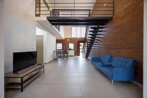 a living room with a blue couch and a brick wall at Macapa - Destination Guyane in Macouria