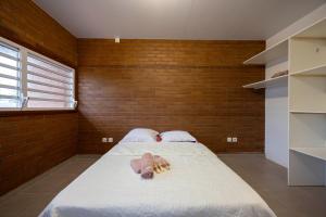 a bedroom with a large bed with a brick wall at Macapa - Destination Guyane in Macouria