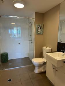 a bathroom with a shower and a toilet and a sink at The Perfect Host @ Curtis Apartments in Gladstone