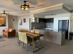 a kitchen and living room with a table and a counter at The Perfect Host @ Curtis Apartments in Gladstone +21 photos
