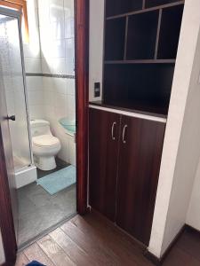 a bathroom with a toilet and a glass door at Hotel Bello, Andrés Bello 1166 in Temuco