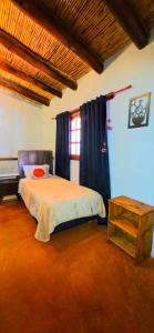 a bedroom with a bed and a table at Tierra Norte - Cabañas in Tilcara