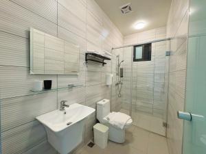 a bathroom with a sink and a toilet and a shower at 海洋星空民宿 in Magong