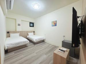 a room with two beds and a flat screen tv at 海洋星空民宿 in Magong +63 photos