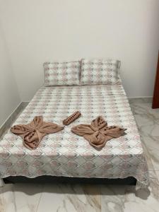 a bed with two pairs of slippers on it at CONDOMINIO JT ll in Ubatuba +4 photos