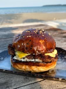 a hamburger with cheese and meat on a plate at Kerfuffle Bay in Koh Rong Island +18 photos