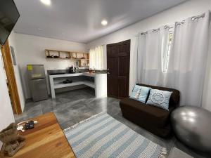 a living room with a couch and a kitchen at Villa Carpintera in Puntarenas