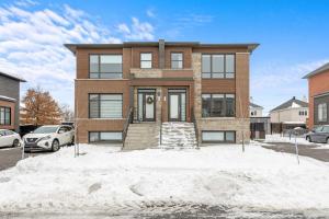 a brick house with snow in front of it at Cozy 1BR Apt perfect for Couple in Longueuil