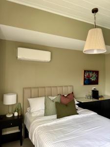 a bedroom with a bed with a white comforter at Robertson Public House and Kitchen in Robertson