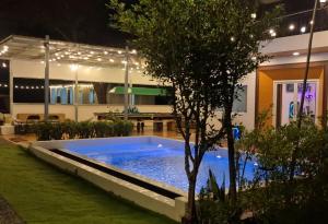 a swimming pool in front of a building at night at ใจฟูฟู พูลวิลล่า in Ban Khok Kratai (1) +27 photos