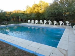a group of chairs sitting next to a swimming pool at Cabañas Mandala in San Marcos Sierras