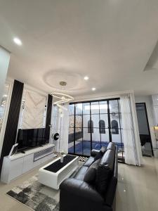 a living room with a couch and a large window at Athara Residence in Tlekung