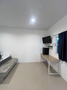 a white room with a desk and a television at The Retreat Hotel Wellness & Spa in Krabi