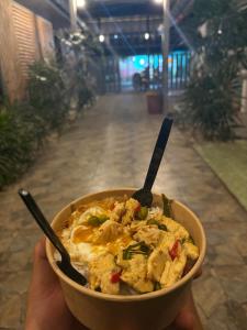 a person holding a bowl of food with a spoon at The Retreat Hotel Wellness & Spa in Krabi
