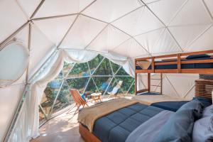a bedroom in a dome tent with a bed and a window at Jungle Glamping K'u' Kuk in Chemuyil +89 photos