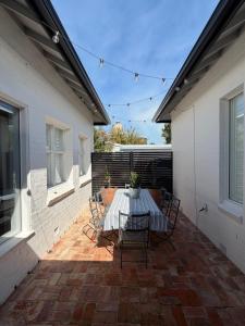 eine Terrasse mit Tisch und Stühlen auf einer Ziegelterrasse in der Unterkunft Towerview in Benalla
