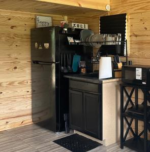 a kitchen with a black refrigerator and a counter at Off the Road Oasis in Lufkin