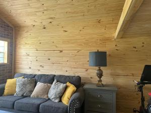 a blue couch in a room with a wooden wall at Off the Road Oasis in Lufkin +9 photos