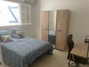 a bedroom with a bed and a cabinet and a table at SOLEY City Break 13 in Les Abymes +9 photos
