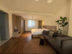 a living room with a couch and a bed at 宣萱民宿 in Mile