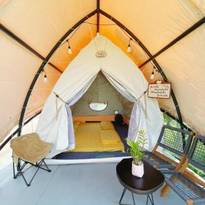 a tent with a table and a chair in it at Sống Chill Homestay in Nam Yên