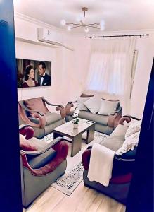 a living room with couches and a table at Stylish Flat at Jannah Compound Sheikh Zayed in Sheikh Zayed