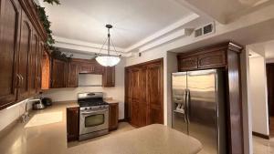 a kitchen with wooden cabinets and a stainless steel refrigerator at Arroyos del Paraíso Residencial Suite A in Manuel F. Martínez