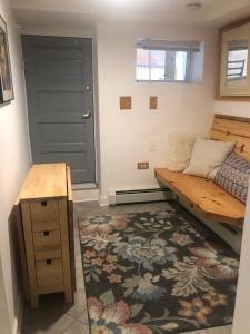 a room with a bed and a bench and a rug at Little haven by the woods in Peekskill