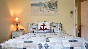 a bedroom with a bed with a red anchor pillow at 409 Princeton in Cape May Point