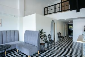 a living room with a couch and chairs on a checkered floor at Siri Space สิริ สเปซ in Ban Khlong Nung (1)