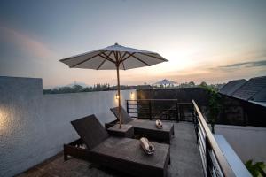 a patio with an umbrella and chairs on a balcony at Alima Villa Ubud in Ubud +54 photos