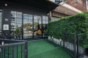 a patio with green grass and a building with windows at Siri Space สิริ สเปซ in Ban Khlong Nung (1)