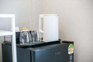 a black appliance with a coffee maker on top of it at Siri Space สิริ สเปซ in Ban Khlong Nung (1)