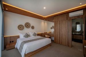 a bedroom with a bed and a bathroom with a sink at Alima Villa Ubud in Ubud