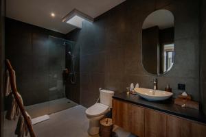 a bathroom with a toilet and a sink and a shower at Alima Villa Ubud in Ubud
